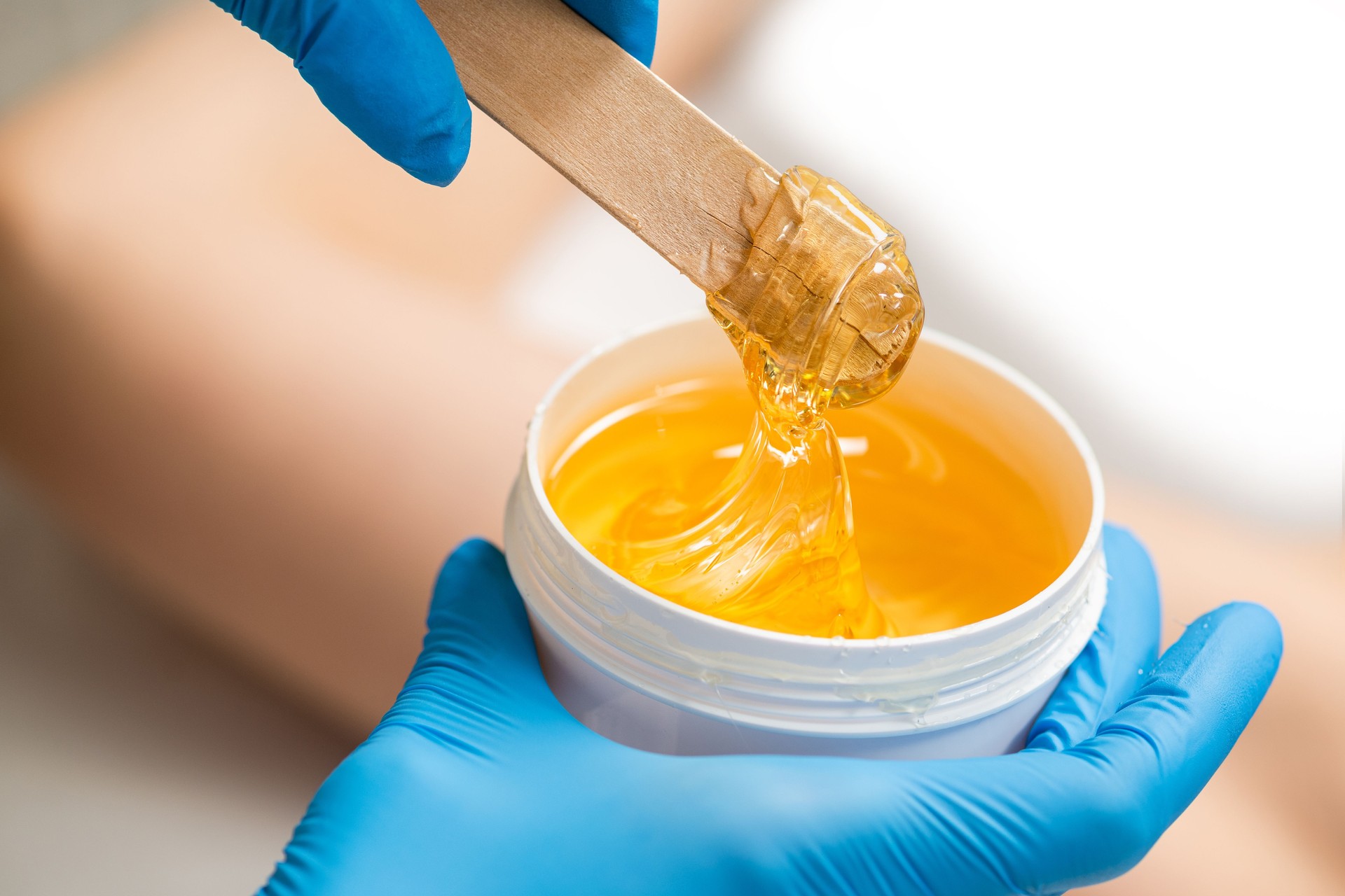 Yellow paste for shugaring on a wooden stick, close-up